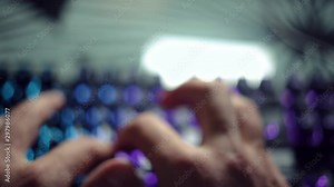 Programmer typing code on a backlit keyboard in a dark room, passionate work at the computer. Male hands quickly type on the keyboard. Freelance programmer or hacker, body parts, close-up soft focus. Stock Video