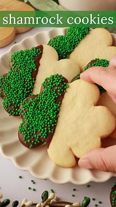 SHAMROCK COOKIES - https://www.ifyougiveablondeakitchen.com/shamrock-st-patricks-day-cookies/ Shamrock St Patrick’s Day cookies are cut-out sugar cookies in the shape of shamrocks. They are dipped in chocolate and garnished with green sprinkles! | If You Give a Blonde a Kitchen