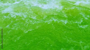 Defocus blurred transparent green colored clear calm water surface texture with splashes and bubbles. Trendy abstract nature background. Water waves in sunlight. Green water shining background.