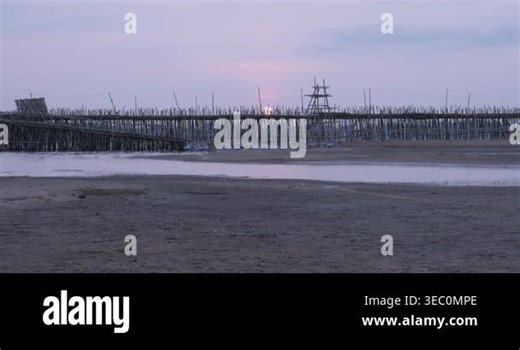 Time lapse sunset view of motorbikes crossing a traditional bamboo bridge over the Mekong River Stock Video Footage - Alamy