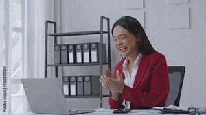 Professional businesswoman celebrates success during online conference call. Expressive emotions and cheering moments captured in a modern office setting