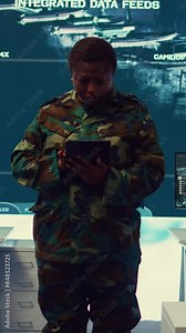 Vertical Video Woman sergeant major working on deployment of electronic warfare tools to disrupt enemy communications. Female army soldier with camouflage uniform operating on high tech gear. Camera B