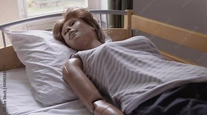 Nursing simulation mannequin on a bed used for training nursing students in a clinical classroom setting