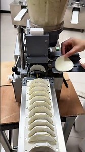 Automatic dumpling making machine producing perfectly folded gyoza on a conveyor belt