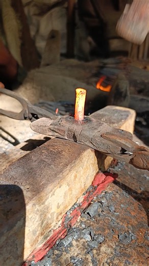 Watch how a skilled blacksmith hand-forges nails from old iron by hammering it into shape."