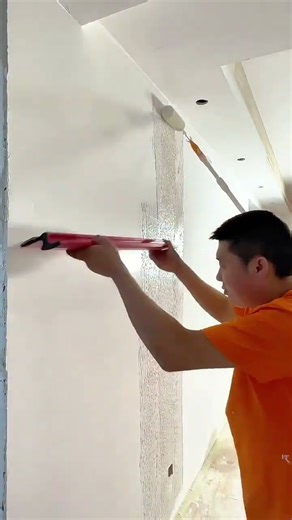Applying textured plaster evenly on the wall surface for a smooth decorative finish