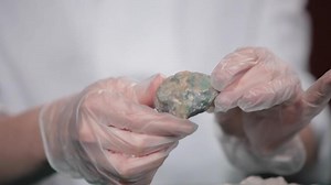 Female Scientist Concentrating On stone In Laboratory close up. Hands young girl doing science experiment