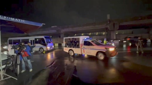 A convoy of PNP vehicles including a coaster and an ambulance escorted by heavily armed police officers are seen entering the private hangar where the private jet carrying dismissed Mayor Alice Guo is expected around 12 midnight. | via Raffy Tima/GMA Integrated News | GMA News