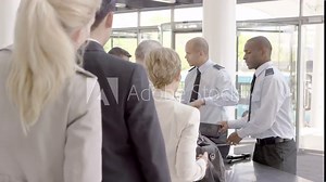 Airport security guards on duty, searching passengers before a flight