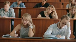 In the Classroom Multi Ethnic Students Listening to a Lecturer and Writing in Notebooks. Smart Young People Study at the College. | Premium Stock Video Footage