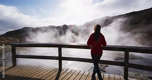 Iceland tourist taking picture of amazing nature with volcano geothermal fields with volcanic activity of fumaroles. Seltun geothermal field in Krysuvik, Reykjanes peninsula, Iceland. Slow motion