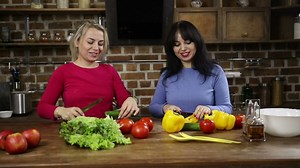 Happy women cutting vegetables at home - Free Stock Video