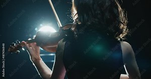beautiful young girl playing the violin during the concert