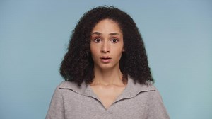 Surprised woman with wide eyes on blue background