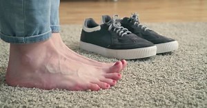 Women's Feet and Sneakers on the Carpet