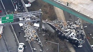 Tractor-trailer carrying empty beer kegs falls from overpass