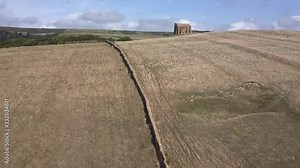 Aerial tracking forward up a the brow of a hill to reveal the amazing St Catherine's Chapel, just next to the village of Abbotsbury. Dorset, England. Cropped