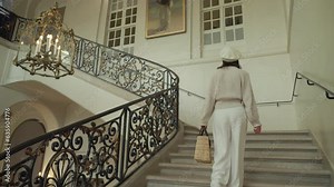 Beautiful girl climbing the ancient stairs in the Paris Museum in France