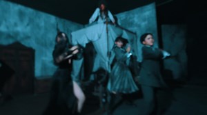 Dramatic dance performance with actors in dark costumes on stage