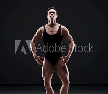 Athletic male ballet dancer showcasing his strength and elegance in a striking leap, dressed in a sleek black leotard. A display of flexibility and talent from this graceful performer