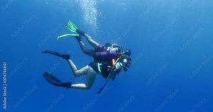 beginner scuba divers learning to dive in blue water underwater scenery of a lady and teacher