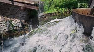 Splashing white water cascades from wooden sluice flume construction, slow motion