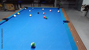 People playing 8-ball pool billiards on blue table. Pool is a classification of cue sports. Stock Video