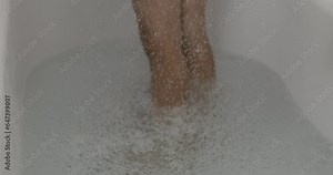 Droplets splashing into bath tub in super slow-motion during night routine