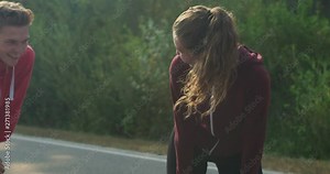 Young couple relaxing and having fun after jogging on country road