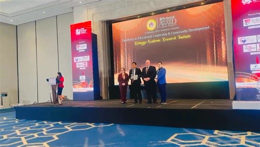 Mr. Kai Sayr , Chair and Executive Director of the Rohingya Academic Research Institute is receiving the Global Excellence and Asia Education Award on behalf of the Rohingya Academic Research Institute . | Mg Aung Hla Shwe