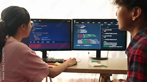 Slow motion back end software developer engineer for computer programming working together on debugging writing computing code, solving complex algorithms display on monitor in office. Burgeoning