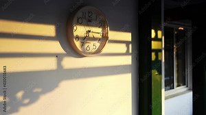 Time-lapse of a clock moving fast with shadow formed by sun shining on a wall of a house Stock Video