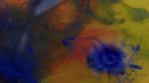 Yellow and black paint splash each other in water against a grey background, colored ink spreads and bursts like a colorful cloud, fluorescent lighting and natural glitter. Slow motion, 4K.
