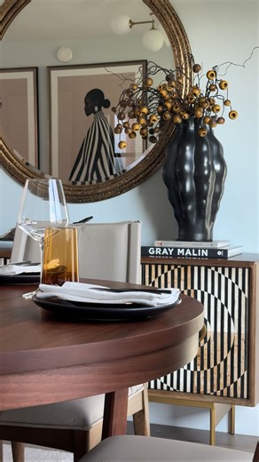 On install day we had the inclination to go ahead and set the dining table for our client. We went with a very simple centerpiece something that you can do at home as well: •Metal decorative tray •Assorted greenery •3 clear vases •3 candles The plate settings are simple to include a black plate, gold saucer, fabric napkin, and silverware. Our client loves wine so for the glass choices we went with a wine glass accompanied by a water glass. For the water glass we chose to do an orange color just 