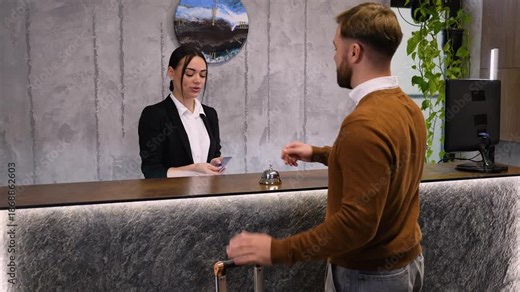 Hotel receptionist greeting guest during check in process