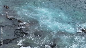 Aerial beautiful beach surf waves on lava rock shore. Big Island, largest, most volcanic active destination. Economy is tourism based. tropical beach recreation and fun. Beautiful clear blue ocean.