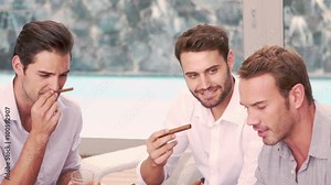 Smiling friends smoking cigar in the living room