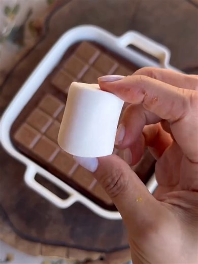 Receita de Bolo de Chocolate com Marshmallow Ingredientes; 3 ovos 160 ml de óleo 200g de açúcar 30g de chocolate em pó 120 ml de água quente 200g de farinha de trigo 10g de fermento (1 colher) Bata no liquidificador os ovos, óleo, açúcar, chocolate em pó e água quente. Bata até tudo de misture. Em uma cumbuca, ja com a tarinha de trigo peneirada, coloque a mistura do liquidificador. Misture com um fuet até que a farinha fique homogênea a massa. Acrescente o fermento e mexa mais um pouco. Coloque