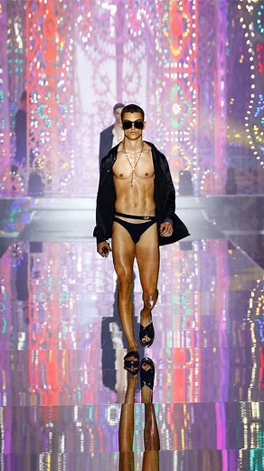 Dolce&Gabbana on Instagram: "#DGLightTherapy: The Men’s Spring Summer 22 Fashion Show takes an evocative journey into the heart of the traditional Italian art of luminarie in celebration of Fatto a Mano, forever part of the Dolce&Gabbana DNA. The #DGMenSS22 look includes a black silk twill shirt over a black lycra swimsuit with golden #DolceGabbana logo on the side. The look is completed with black acetate #DGEyewear, iconic rosary necklace and black slippers with matching black crystals. Relive