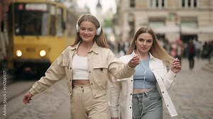 Young women recording dance video. Friends doing trendy dance moves in front of a camera. Vibrant young people creating content for their social media vlog. Social media trends