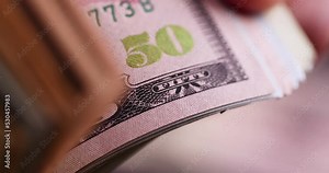 flip through and check American dollars, American monetary unit dollars as money for saving