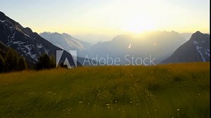 The gentle rustling of grass and the distant call of a mountain goat can be heard in the peaceful alpine meadows at sunrise.