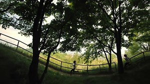 Silhouette Running two girls in the park, side view, morning jogging of two athletes, city view, running near the raft, running of two teenage girls on the background of the city