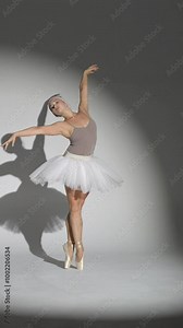 Performance, graceful ballerina in a pink tutu dance and perform dramatic choreographic elements on a white background, windy and beautiful dance, vertical video.