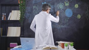 Scientist drawing DNA helix on blackboard.