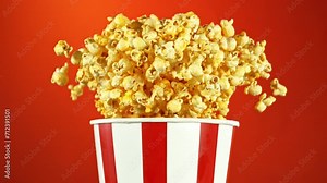 Super Slow Motion of Exploding popcorn from Bucket. Isolated on Red Background. Studio Shot of Flying Food. Filmed on High Speed Cinema Camera, 1000fps.