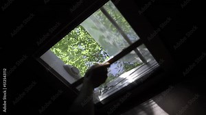 Closing anti-insect mosquito net on a ceiling window to prevent insects and other bugs getting inside a campervan. Woman closing retractable pleated insect net on a motorhome roof window.