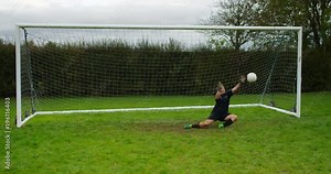 4K Goalkeeper makes a save at girls' football match. Slow motion.