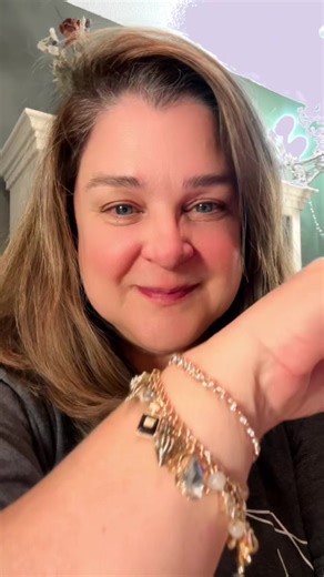 Twin Chain Charm Necklace – One of a Kind Turn heads with movement, sound, and shine. This one-of-a-kind charm necklace features over 20 charms and beads layered across two chains—one warm gold-tone chain paired with a delicate pearl chain for contrast and texture. Finished with three rope circle loops and a bold toggle clasp, this piece brings playful energy with every step. A perfect mix of soft color, mixed textures, and joyful jingle, this necklace is made to stand out while still styling ea