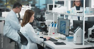 Medical Research and Development Laboratory: Motivated Asian Female Scientist Working on a Computer with Advanced DNA Diagnostic Software on Display. Modern Genetic Engineering Lab